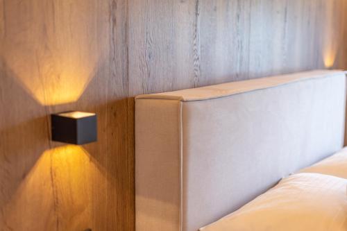 a bedroom with a white bed and a wooden wall at Lenni´s Apartments in Bruck an der Großglocknerstraße
