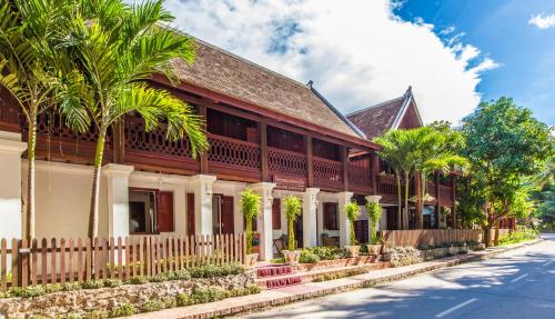 a building with palm trees in front of it at Mekong Riverview Hotel in Luang Prabang