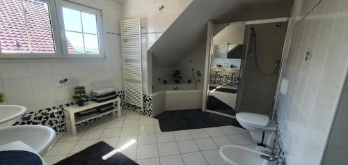 a bathroom with a shower and two sinks and a tub at top Haus 160m2 Europapark,Strasburg,Schwarzwald in Appenweier