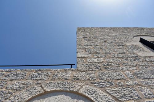 a view of a stone wall with a blue sky at Akroyiali Apartments in Gerolimenas