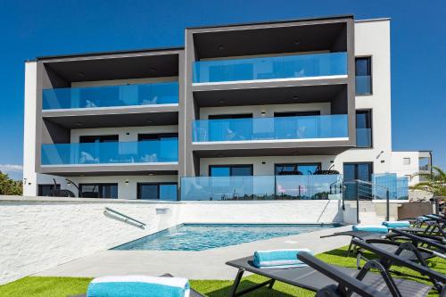 an apartment building with a swimming pool and chairs at PS Apartments in Pula