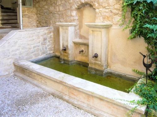 a small pool of water in the corner of a building at Maison Passère in Forcalquier