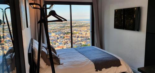 een slaapkamer met een bed en een groot raam bij Studio terrasse Indépendante Vue Exceptionnelle in Sète