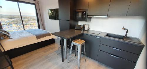 - une cuisine avec évier et un lit dans une chambre dans l'établissement LE ROUQUIER Studio Terrasse, Vue Exceptionnelle, Climatisation, à Sète