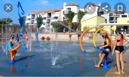 um grupo de meninas brincando em um parque aquático em Superbe appartement avec piscine em Le Barcarès