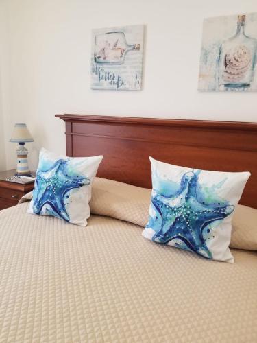 a bed with two pillows on top of it at Casa Bonequinha in Nazaré