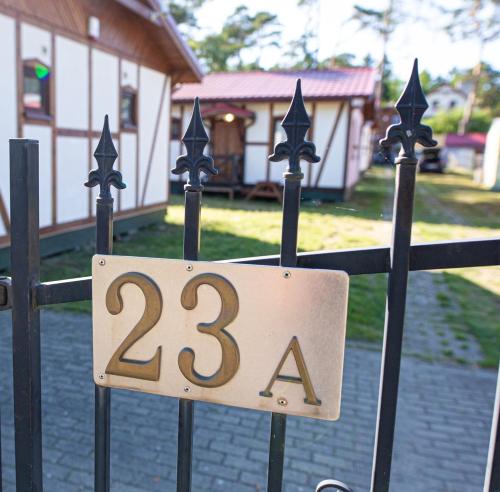 a sign on a fence with the number twentyfour at Pustkowo Domki Wakacyjne u Marka in Pustkowo