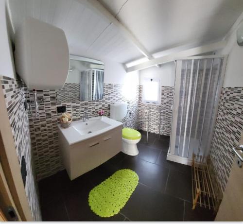 a bathroom with a white sink and a green rug at CRISVAN HOME in Capo Rizzuto