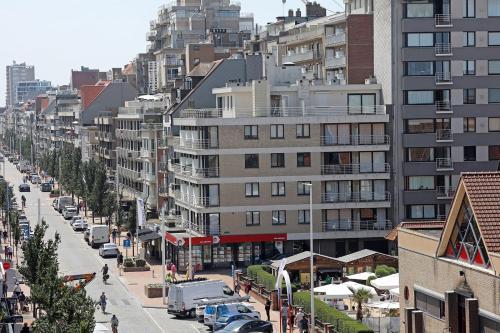 a city street with tall buildings and cars on the road at Hotel Uilenspiegel in Nieuwpoort