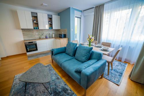 Kedar apartment في نوفي ساد: غرفة معيشة مع أريكة زرقاء وطاولة