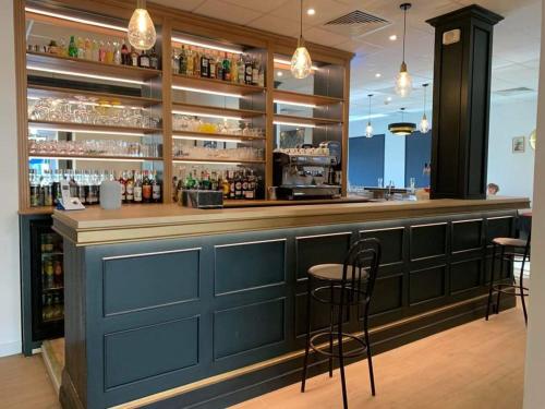 a blue bar with stools in a restaurant at LE PATIO in Millau