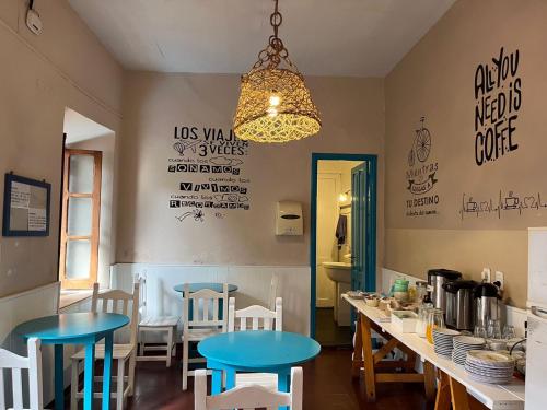 a kitchen with blue tables and chairs in a room at Ferienhaus Hostel Salta in Salta