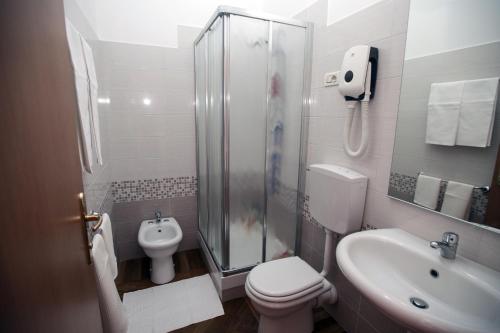 a bathroom with a shower and a toilet and a sink at Italy Inn in Genoa