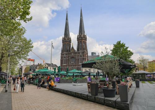 a large cathedral with two spires on a city street at Ecolodge Tilburg met zwembad in groene oase bij centrum in Tilburg