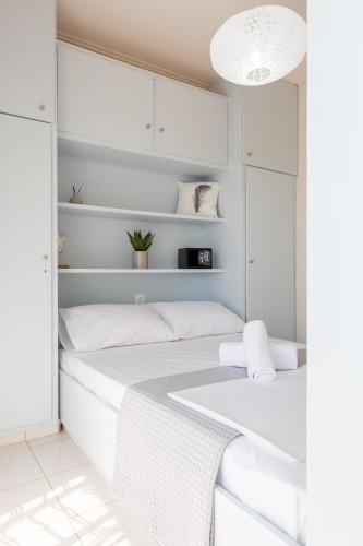 a bedroom with two beds with white cabinets at Loutraki Getaway - Cozy and Quiet Nest in Loutraki