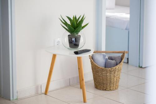 a table with a remote control and a plant on it at Loutraki Getaway - Cozy and Quiet Nest in Loutraki