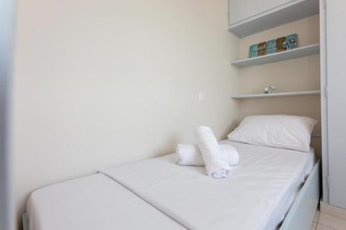a white bed with two white towels on it at Loutraki Getaway - Cozy and Quiet Nest in Loutraki