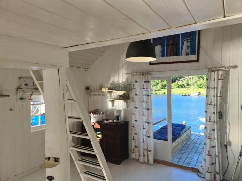 a room with a staircase and a view of the water at Usjenert idyllisk Sjøbu in Kragerø