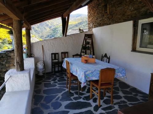 a dining room with a table and chairs and a view at Casa do Alto - Benfeita in Benfeita