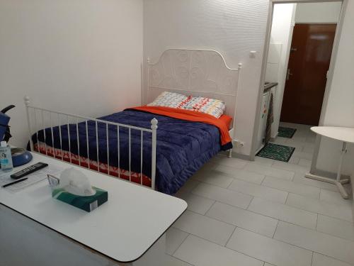 une petite chambre avec un lit et une table dans l'établissement JINA, à Strasbourg