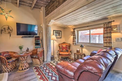 a living room with leather furniture and a flat screen tv at Authentic Adobe Abode Less Than 1 Mile to Sante Fe Plaza! in Santa Fe