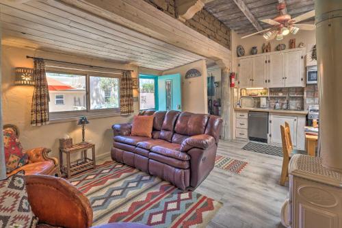 a living room with a leather couch and a kitchen at Authentic Adobe Abode Less Than 1 Mile to Sante Fe Plaza! in Santa Fe