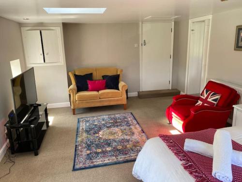 a room with two chairs and a couch and a television at Kitty’s Place, Apartment, Eden Valley, Cumbria in Brampton
