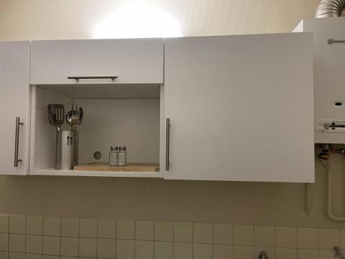 une cuisine avec des placards blancs dans l'établissement Studio aux portes de Paris, à Chatou