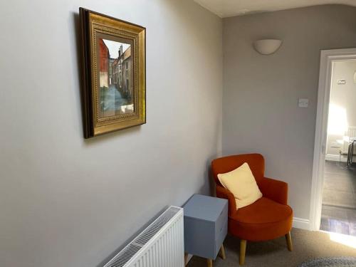 a living room with a chair and a mirror at Kitty’s Place, Apartment, Eden Valley, Cumbria in Brampton