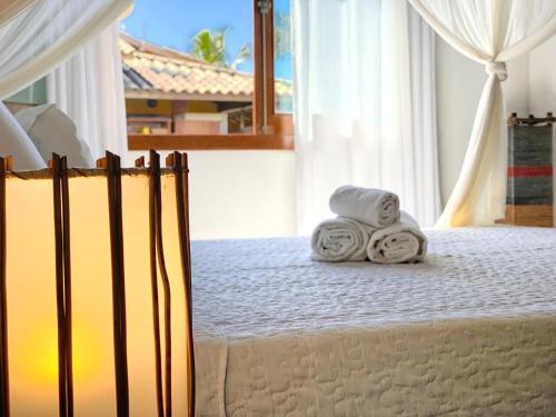 a room with a bed with towels on it at Casa Villa Cristian Pé na Areia in Arraial d'Ajuda