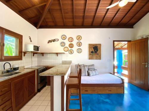 a kitchen with a bed in the middle of a room at Casa Villa Cristian Pé na Areia in Arraial d'Ajuda