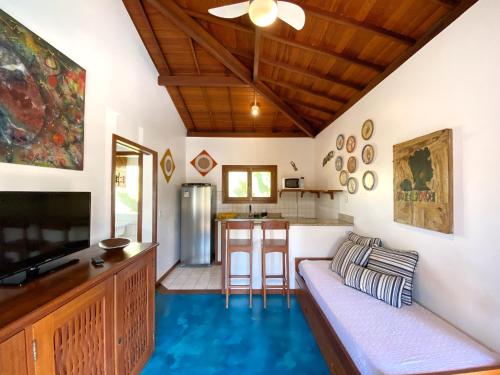 a living room with a couch and a kitchen at Casa Villa Cristian Pé na Areia in Arraial d'Ajuda