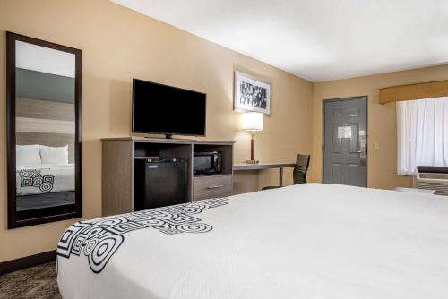a hotel room with a bed and a flat screen tv at Best Western Apalach Inn in Apalachicola