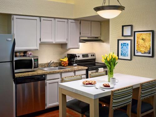a kitchen with white cabinets and a kitchen table with a white counter top at Sonesta Simply Suites Cleveland Westlake in Westlake