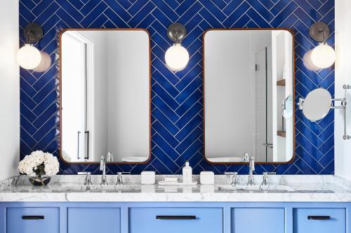 a bathroom with two sinks and two mirrors at The Tides Inn in West Irvington