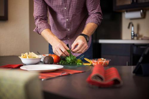 a man preparing food on a counter in a kitchen at Sonesta Simply Suites St Louis Earth City in Earth City