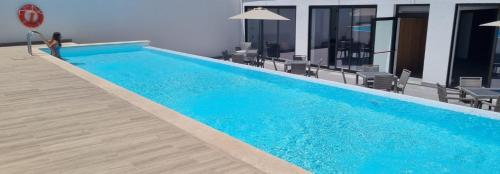 a woman is standing next to a swimming pool at Casazul M&B in Cercal