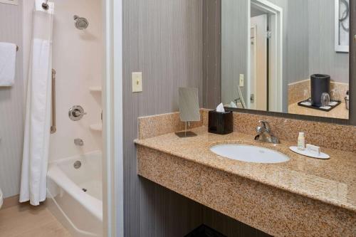 a bathroom with a sink and a mirror at Sonesta Select Indianapolis Carmel in Carmel