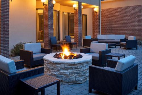 a patio with a fire pit with chairs and tables at Sonesta Select Indianapolis Carmel in Carmel
