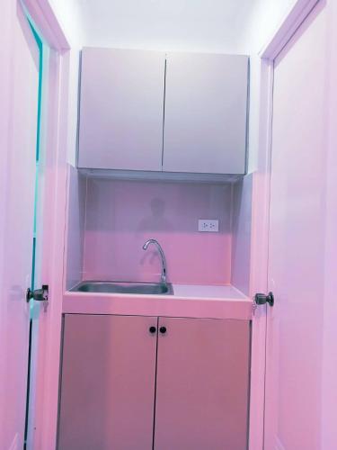 レガスピにあるLee Residences by JALのピンクのキャビネット内のシンク付きのキッチン