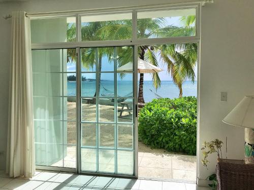 a room with a sliding glass door looking out at the beach at Sunset Cove - Vacation In Paradise! in Nassau