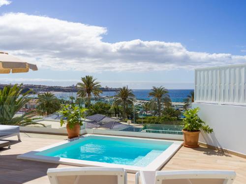 una piscina en un balcón con vistas al océano en Pasitoblanco Porto Mare 7 Seaview Villa private heated pool, en Pasito Blanco