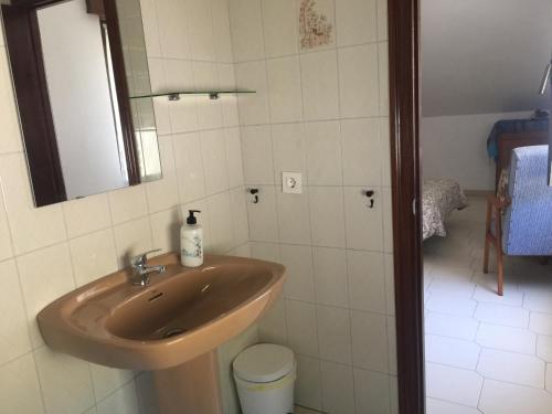 a bathroom with a sink and a mirror at Pensión El Pozo in Cudillero