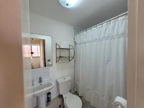 a white bathroom with a toilet and a sink at Atacama Valley 03 in Copiapó