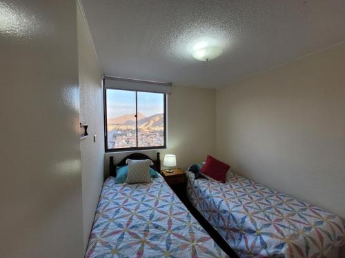 um pequeno quarto com 2 camas e uma janela em Atacama Valley 03 em Copiapó