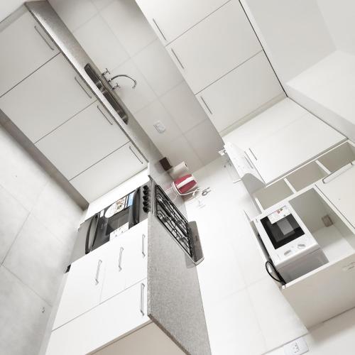 an overhead view of a kitchen with white cabinets at PR Apart - Alquileres Temporarios in San Miguel de Tucumán