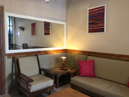 sala de estar con sofá, mesa y espejo en Ferienhaus Hostel Salta en Salta