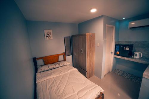 a bedroom with a bed and a wooden cabinet at HK Hotel Kbartolo in Lucena