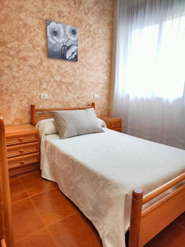 a bedroom with a bed and a window at Mesón da Pedra in Burela de Cabo