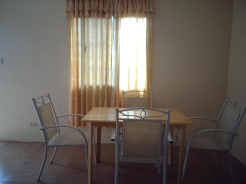 a table and chairs in a room with a window at JW Apartments in Angeles
